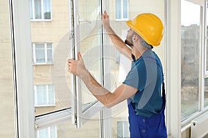 Construction worker installing window in house
