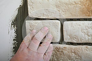 Construction worker installing tiles on a wall