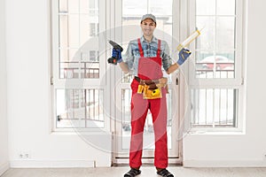 Construction worker installing window in house. Handyman fixing the window with screwdriver