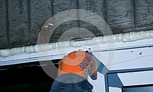 Construction worker installing window in house.