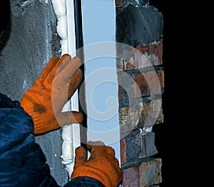 Construction worker installing window in house.