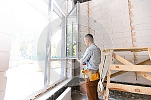 Construction worker installing window in house