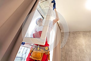 Construction worker installing window in house