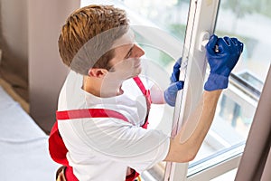 Construction worker installing window in house