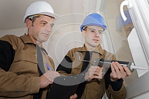 Construction worker installing window in house