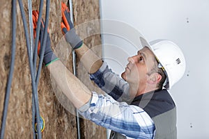 construction worker insulating brick wall with glass wool