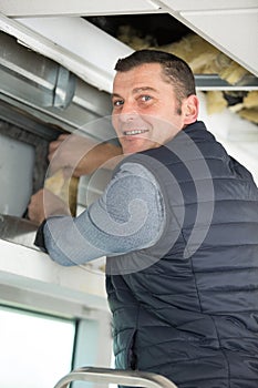 construction worker insulating plaster wall with glass wool