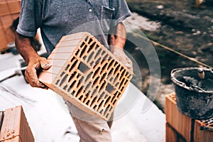 Construction worker laying bricks on walls, carrying and moving around bricks