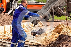 Construction worker laying cement or concrete into the foundation formwork