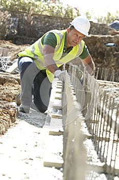 Construction Worker Laying Foundations