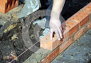Construction worker lays bricks