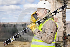 Construction worker with level and cell phone