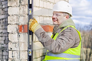 Construction worker with level near wall