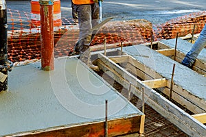 Construction worker leveling concrete pavement. pouring concrete pavement