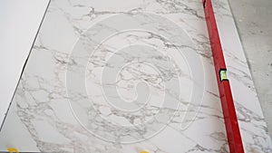 Construction worker leveling marble tile during floor installation