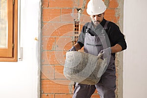 Construction worker is lifting a heavy carrycot