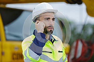 Construction worker listening to instructions via walkie-talkie