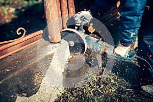 Construction worker,man, engineer using handy circular saw for cutting reinforced steel bars