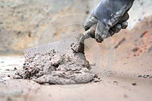 Construction worker Man hand using trowel to mix mortar.