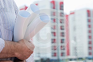 A construction worker man holding in hands blueprints