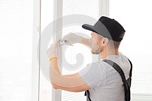 Construction worker man install plastic white upvc windows in house