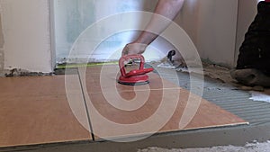 Construction worker man measure and place floor tiles