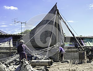 Construction worker man team working piling equipment. Building house by use three legs crane. Install steel structure.