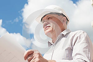 A construction worker man in white helmet holding