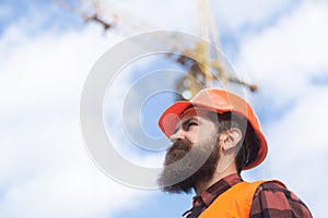 Construction worker man in work clothes and a construction helmet. Building and construction site concept.