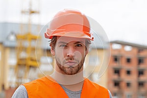 Construction worker man in work clothes and a construction helmet. Improvement and renovation. Brutal man builder