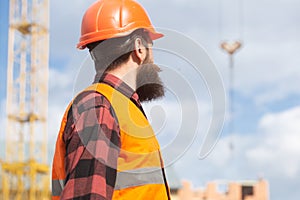 Construction worker man in work clothes and a construction helmet. Industrial theme.