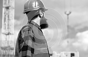 Construction worker man in work clothes and a construction helmet. Industrial theme.