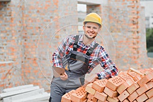 Construction worker man in work clothes and a construction helmet. Portrait of positive male builder in hardhat working