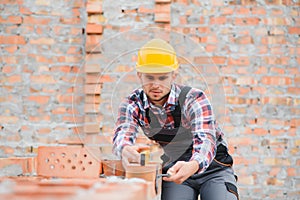 Construction worker man in work clothes and a construction helmet. Portrait of positive male builder in hardhat working