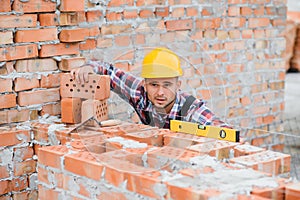 Construction worker man in work clothes and a construction helmet. Portrait of positive male builder in hardhat working