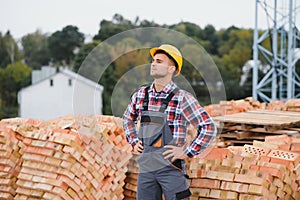 Construction worker man in work clothes and a construction helmet. Portrait of positive male builder in hardhat working