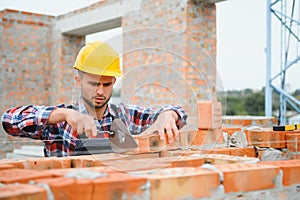 Construction worker man in work clothes and a construction helmet. Portrait of positive male builder in hardhat working