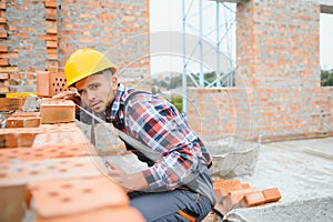 Construction worker man in work clothes and a construction helmet. Portrait of positive male builder in hardhat working