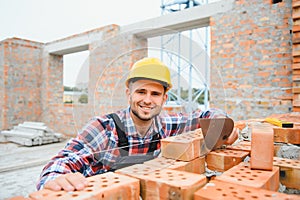 Construction worker man in work clothes and a construction helmet. Portrait of positive male builder in hardhat working