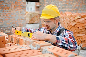 Construction worker man in work clothes and a construction helmet. Portrait of positive male builder in hardhat working