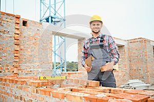 Construction worker man in work clothes and a construction helmet. Portrait of positive male builder in hardhat working