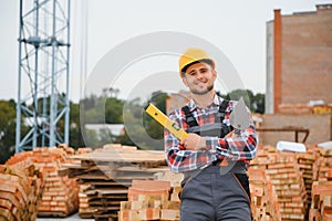 Construction worker man in work clothes and a construction helmet. Portrait of positive male builder in hardhat working