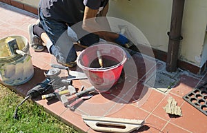Construction worker with a mask installing tiles on the wall