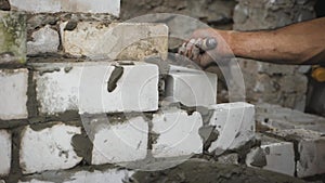 Construction worker or mason laying bricks and creating walls. Bricklayer laying bricks to make a wall. Building a