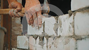 Construction worker or mason laying bricks and creating walls. Bricklayer laying bricks to make a wall. Building a