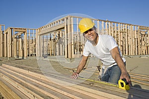 Construction Worker Measuring Planks