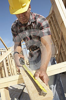 Construction Worker Measuring Timber