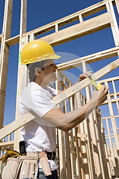 Construction Worker Measuring Timber