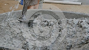 Construction worker mixing concrete with water for building