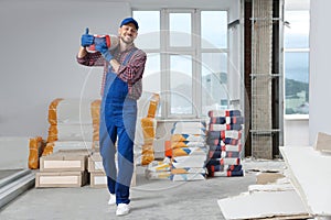 Construction worker with new building materials in room prepared for renovation